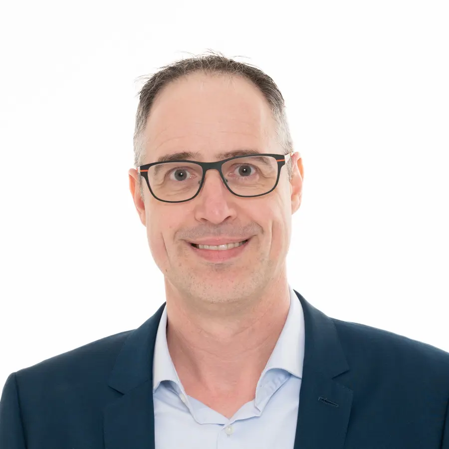 Een profiel foto van Dominique Verweij in een blauw pak met lichtblauw overhemd.