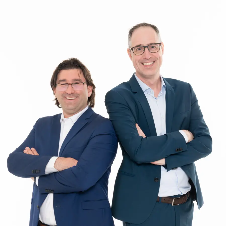 Een foto van John-Paul Straver en Dominique Verweij waar ze met de rug tegen elkaar staan en armen over elkaar.