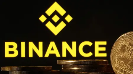 Logo van Binance met stapels gouden munten op de voorgrond.