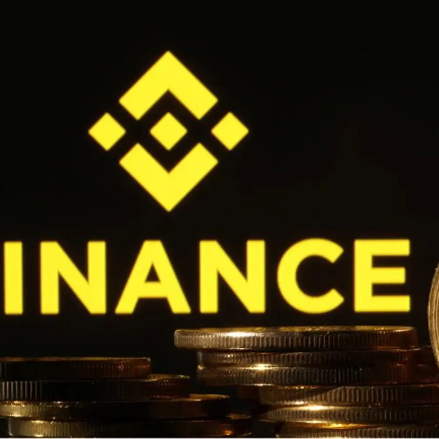 Logo van Binance met stapels gouden munten op de voorgrond.